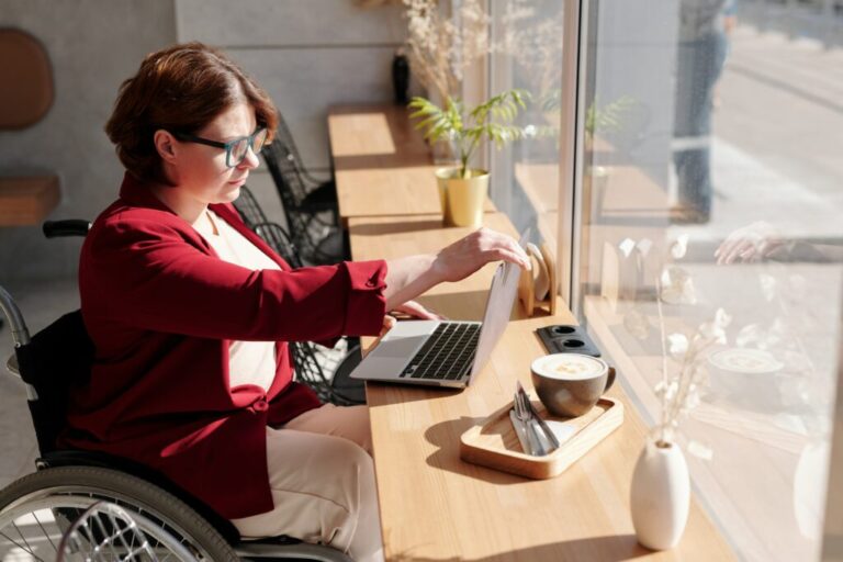 Persoon in een rolstoel gebruikt een laptop
